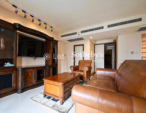 Spacious living room with leather furniture and large wooden entertainment unit