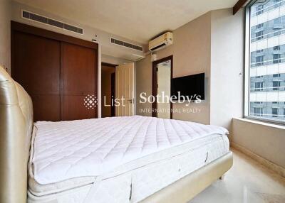 Well-lit bedroom with large window and built-in storage