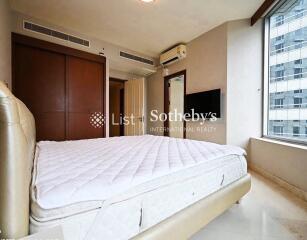 Well-lit bedroom with large window and built-in storage