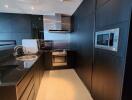 Modern kitchen with black cabinetry and integrated appliances