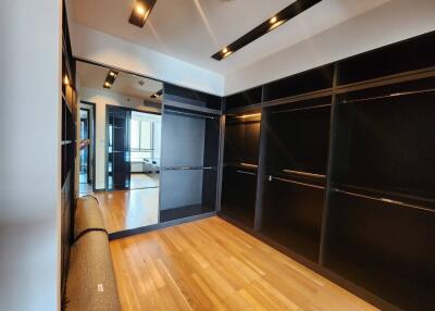 Spacious walk-in closet with hardwood floors and built-in shelves