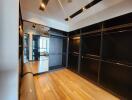 Spacious walk-in closet with hardwood floors and built-in shelves