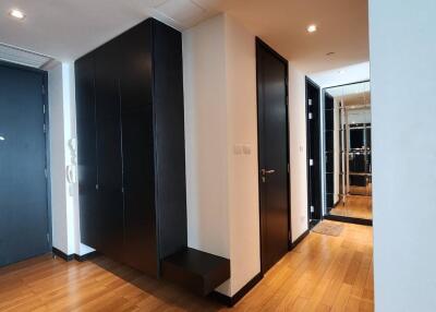 Modern hallway with wooden flooring and black doors