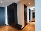 Modern hallway with wooden flooring and black doors