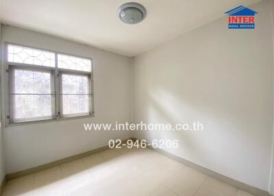 Empty bedroom with tiled flooring and metal-grilled windows