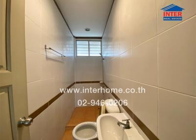 Bathroom with white tiles and a small window