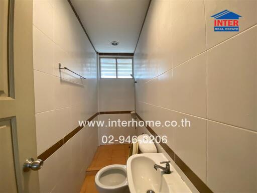 Bathroom with white tiles and a small window