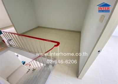 Staircase landing with tiled floor and red railing