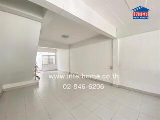 Spacious living room with white tiled floor and large windows