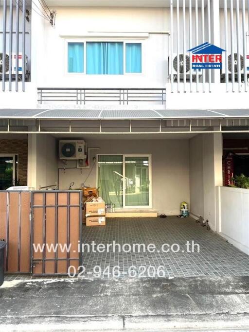 Front view of a residential building with a garage and balcony