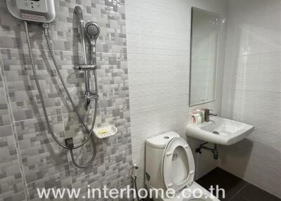 Modern bathroom with shower, toilet, sink, and mirror