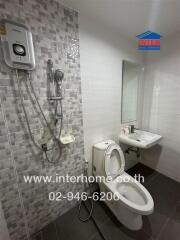 Modern bathroom with shower, toilet, sink, and mirror