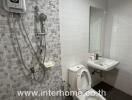 Modern bathroom with shower, toilet, sink, and mirror