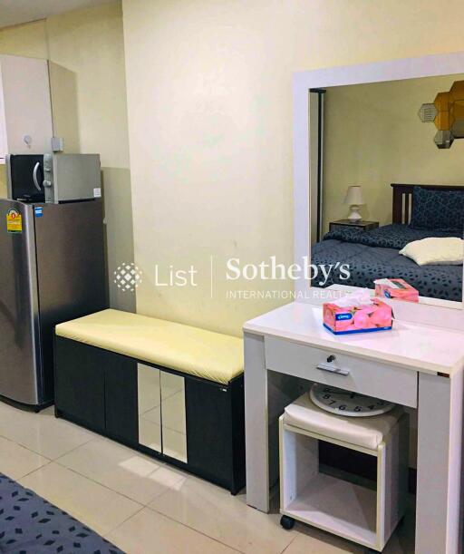 Modern bedroom with vanity, refrigerator, and seating area