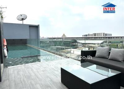 Rooftop swimming pool area with seating and city view