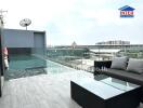 Rooftop swimming pool area with seating and city view