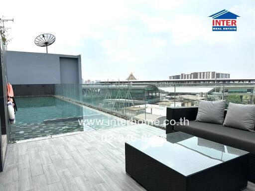 Rooftop swimming pool area with seating and city view