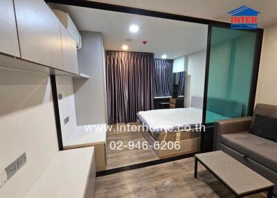 Modern bedroom with sliding glass door, featuring a bed, sitting area, and built-in furniture