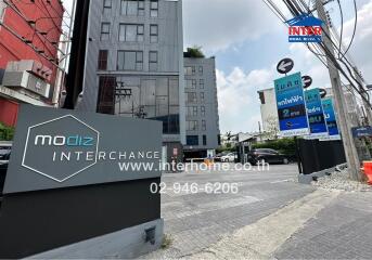 Main entrance of residential building with signage and associated real estate logos