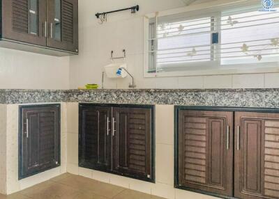 Modern kitchen with dark cabinetry and granite countertop