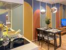 Modern kitchen and dining area with colorful, abstract accent wall