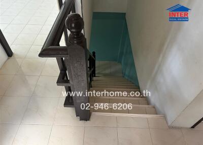 Staircase leading down with wooden handrail