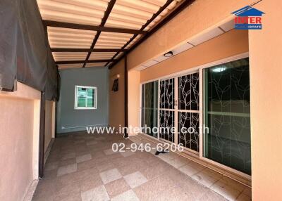 Covered outdoor area with tiled flooring and sliding glass doors