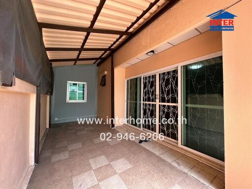 Covered outdoor area with tiled flooring and sliding glass doors