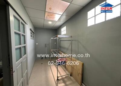 Laundry room with drying racks and storage space