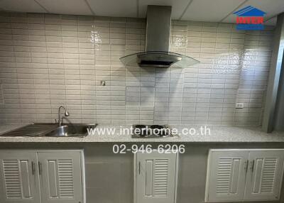 Kitchen with modern appliances and tiled backsplash