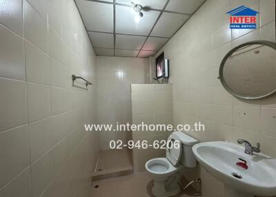 Bathroom with basic fixtures, tiled walls, and small window.