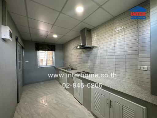 Modern kitchen with tiled backsplash and stainless steel range hood