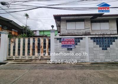 Exterior view of a building with adjacent fence and gate