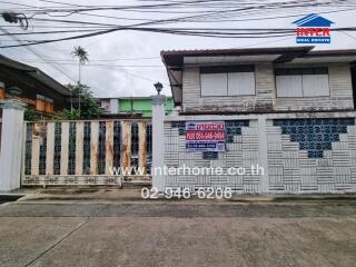 Exterior view of a building with adjacent fence and gate