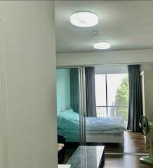 Bedroom with bed, sliding glass doors, and large window.