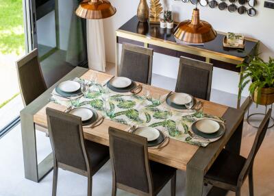 Dining room with a wooden table set for six people and a sideboard with decorative items