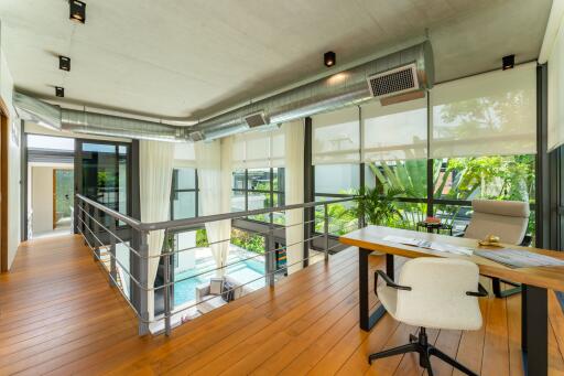 Modern study with large windows and greenery view