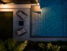 Night view of outdoor seating area next to a pool