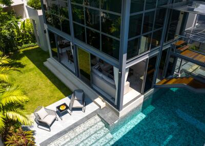 Modern building with glass walls, pool, and outdoor seating