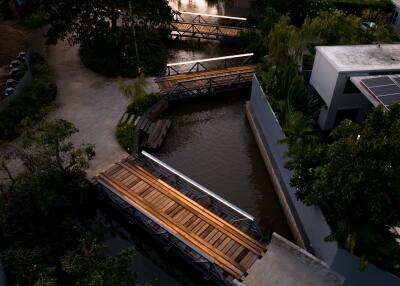 Overhead view of modern building with adjacent waterway and wooden bridges