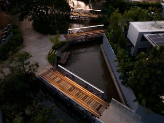 Overhead view of modern building with adjacent waterway and wooden bridges