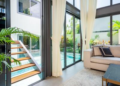 Modern living room with large windows overlooking a pool