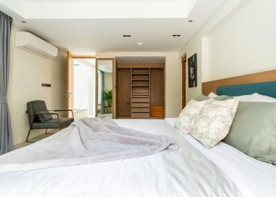 Modern bedroom with double bed, closet, and seating area