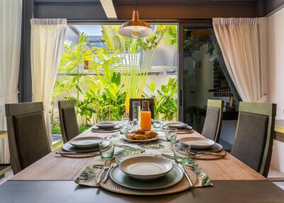 Dining area with a table set for a meal and garden view