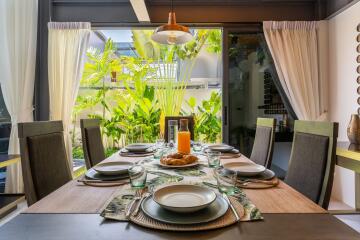 Dining area with a table set for a meal and garden view