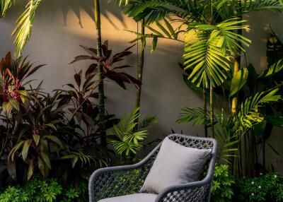 Outdoor seating area with lush greenery and chairs