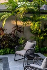 Outdoor seating area with lush greenery and chairs