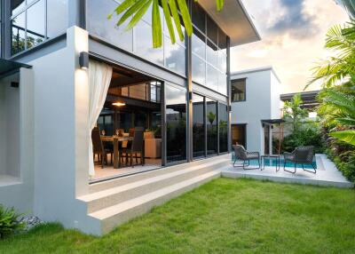 Modern residential building with outdoor seating area and garden