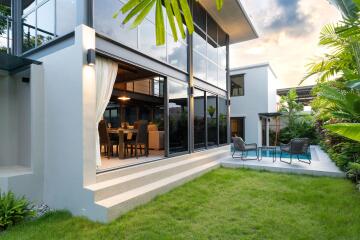 Modern residential building with outdoor seating area and garden