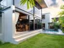 Modern residential building with outdoor seating area and garden